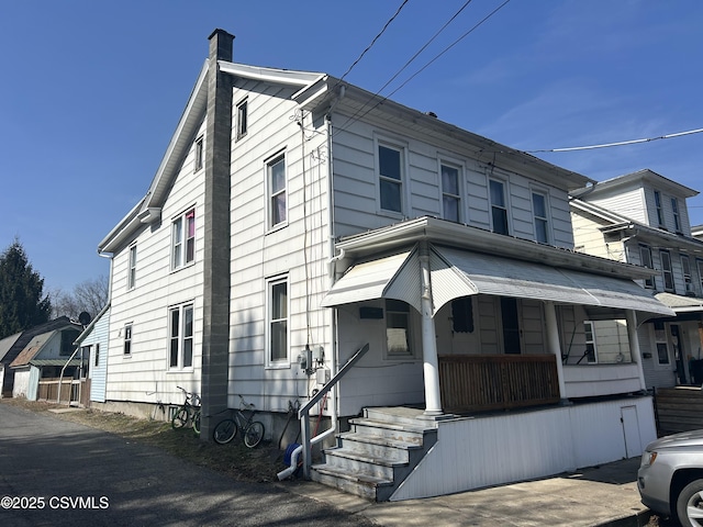 view of front of home with a porch and a chimney