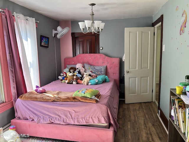 bedroom featuring an inviting chandelier and wood finished floors