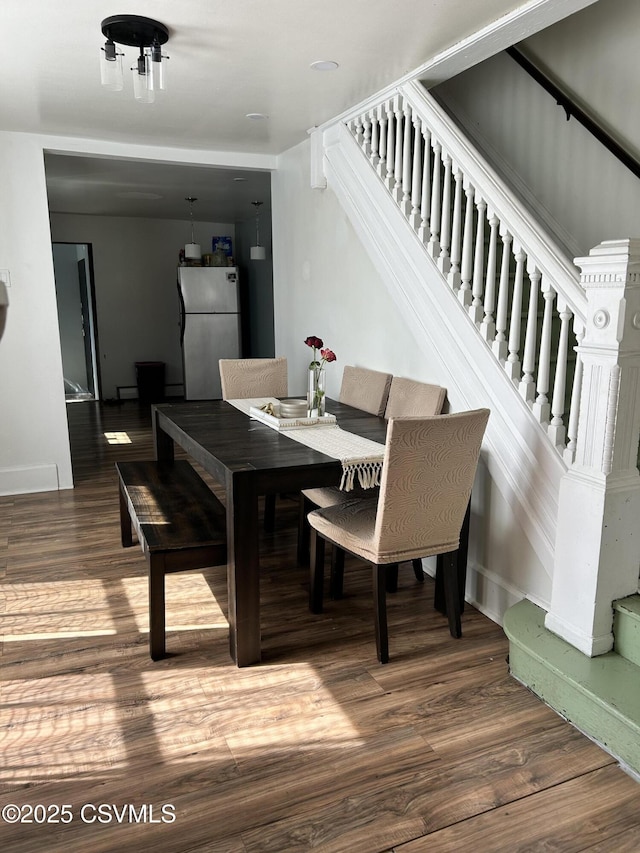 dining area with stairway and wood finished floors