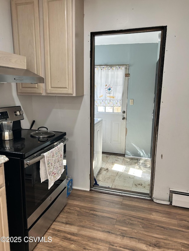 kitchen with wood finished floors, light countertops, electric stove, a baseboard heating unit, and wall chimney exhaust hood