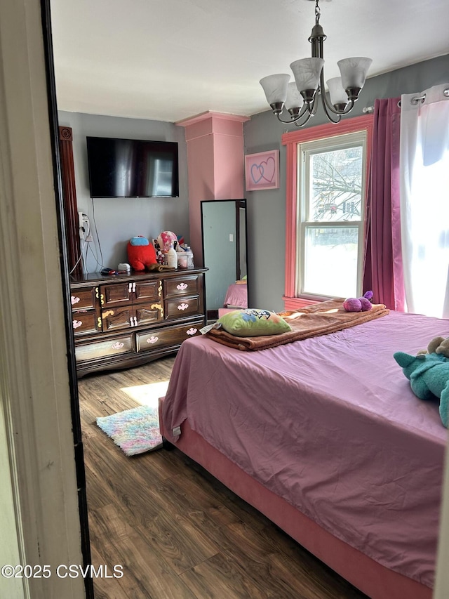 bedroom with a notable chandelier and wood finished floors