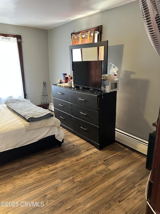 bedroom with dark wood-type flooring and a baseboard radiator