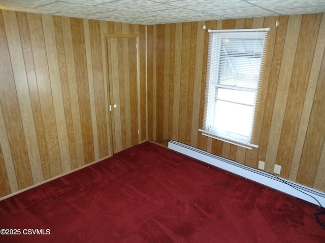 carpeted spare room featuring baseboard heating