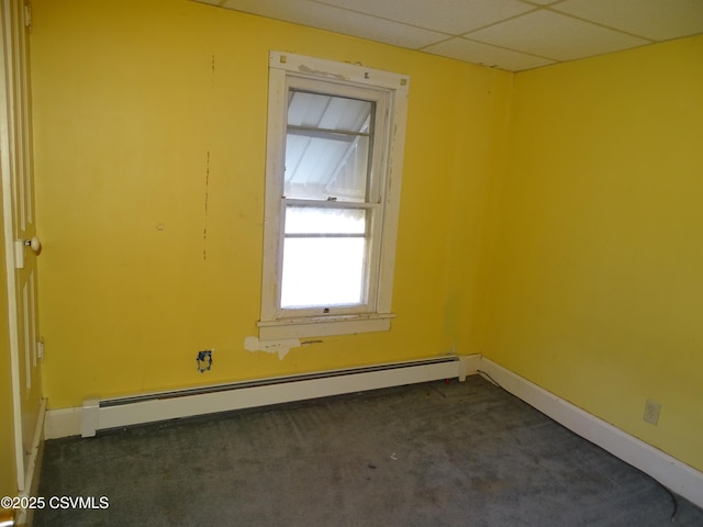 unfurnished room featuring dark colored carpet, a baseboard heating unit, a paneled ceiling, and baseboards