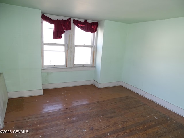 unfurnished room featuring baseboards and hardwood / wood-style flooring