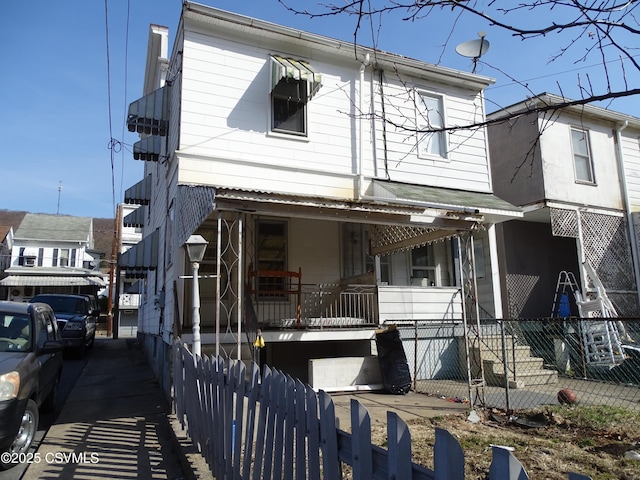 view of front of home featuring a porch and fence