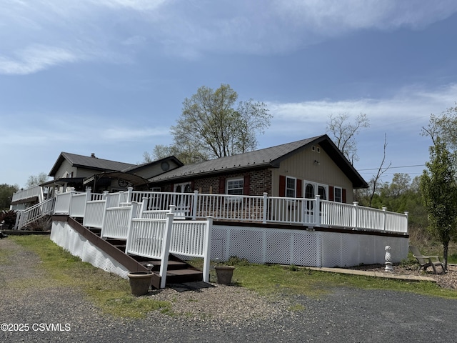 rear view of house with a deck and brick siding