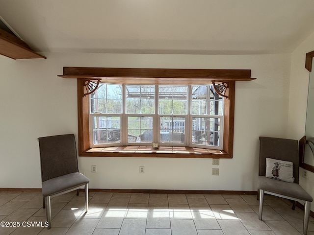 sitting room with baseboards and tile patterned flooring
