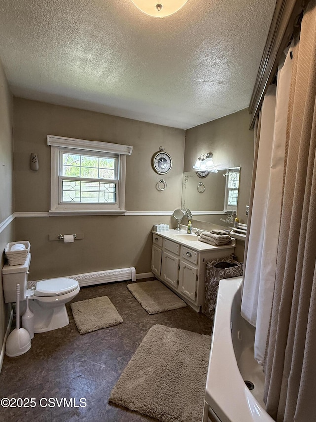bathroom with vanity, a bathing tub, toilet, and a textured ceiling