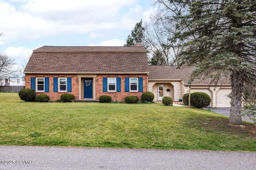 128 S 17th St, Lewisburg, PA 17837 - colonial inspired home with an attached garage, roof with shingles, a front yard, and brick siding