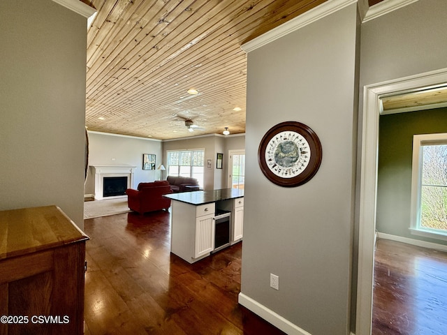 kitchen featuring dark wood finished floors, white cabinetry, crown molding, and dark countertops