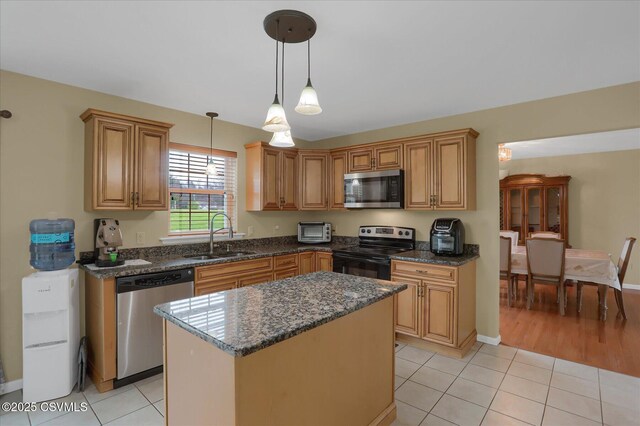 kitchen featuring a sink, pendant lighting, appliances with stainless steel finishes, and light tile patterned flooring