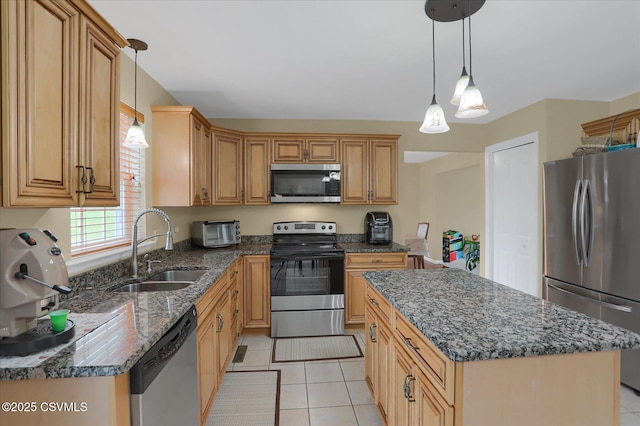 kitchen with stainless steel appliances, a sink, light tile patterned flooring, and dark stone countertops