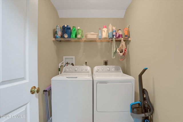 clothes washing area featuring separate washer and dryer and laundry area