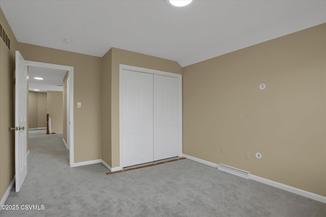 unfurnished bedroom with a closet, visible vents, baseboards, and carpet floors