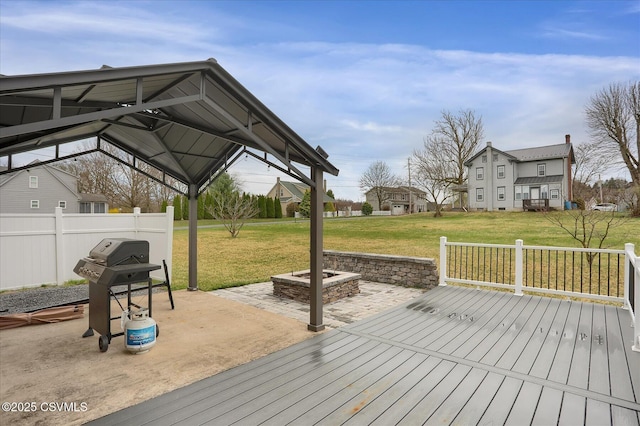 wooden deck featuring a yard, an outdoor fire pit, a grill, and a patio