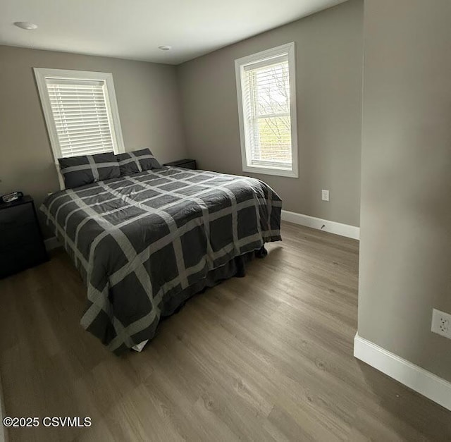 bedroom featuring baseboards and wood finished floors