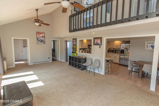 living area with baseboards, light carpet, a ceiling fan, high vaulted ceiling, and a baseboard radiator