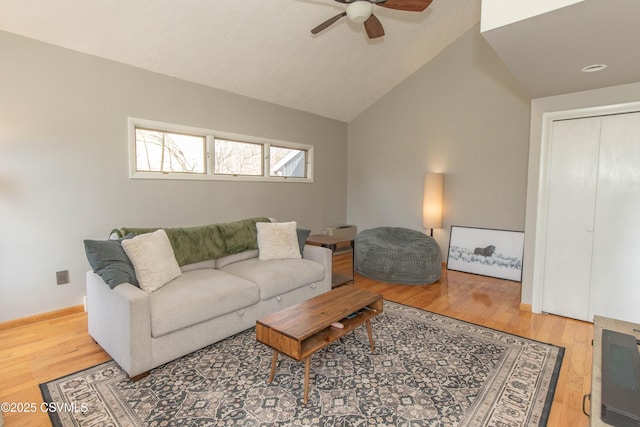 living room with a ceiling fan, wood finished floors, and vaulted ceiling