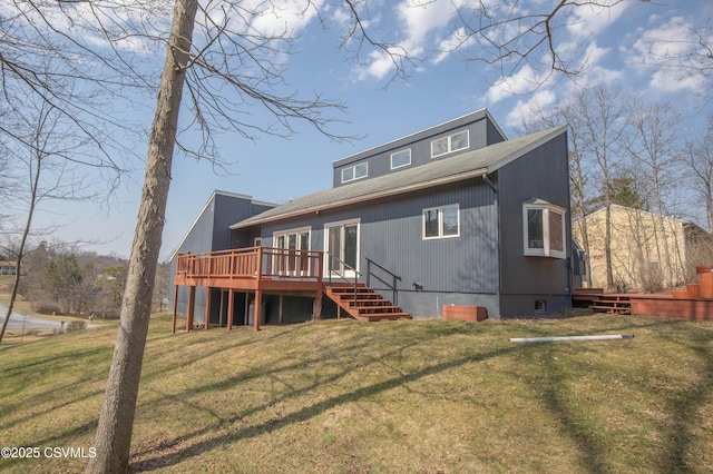 back of house with a shingled roof, a deck, and a lawn