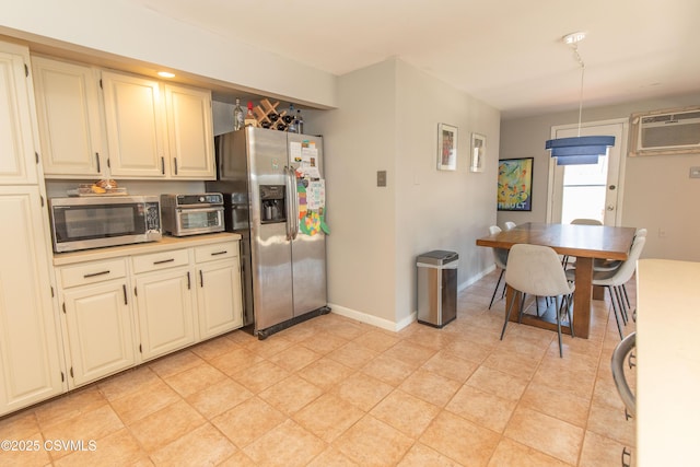kitchen with appliances with stainless steel finishes, light countertops, an AC wall unit, baseboards, and a toaster