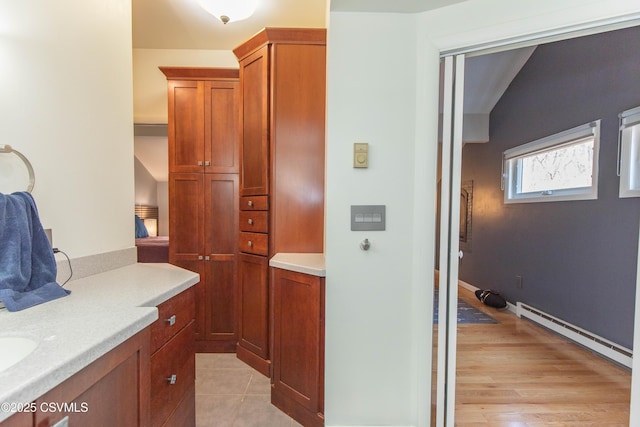 bathroom featuring vanity, baseboard heating, and wood finished floors