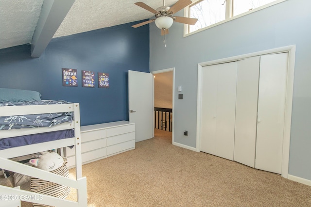 bedroom with high vaulted ceiling, beamed ceiling, a textured ceiling, a closet, and carpet floors