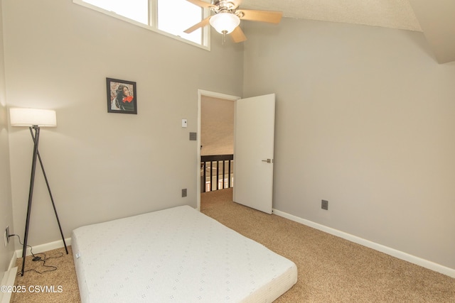 bedroom with light carpet, baseboards, a ceiling fan, and a towering ceiling