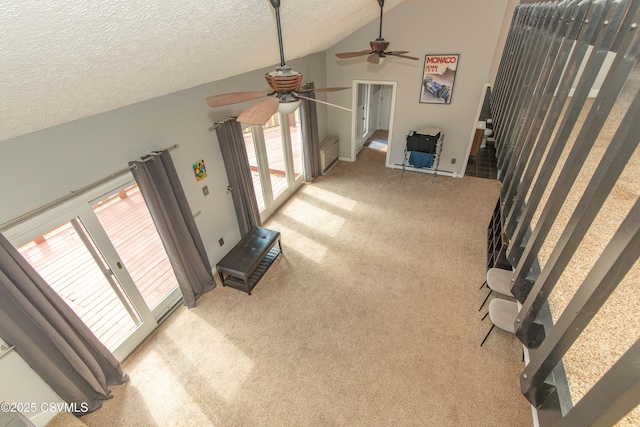 unfurnished living room with a textured ceiling, ceiling fan, lofted ceiling, and carpet floors