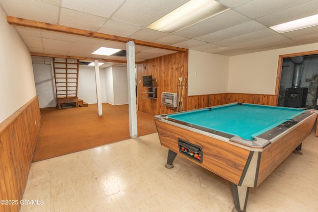 rec room with wood walls, tile patterned floors, a drop ceiling, and wainscoting