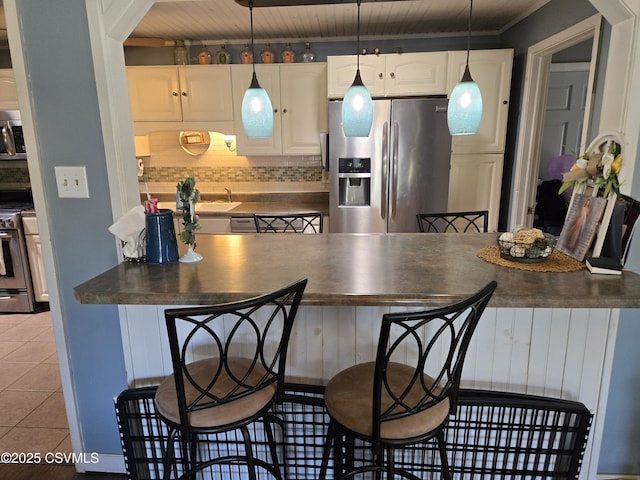444 Frederick Dr, Watsontown, PA 17777 - kitchen with white cabinets, light tile patterned flooring, dark countertops, stainless steel appliances, and decorative backsplash