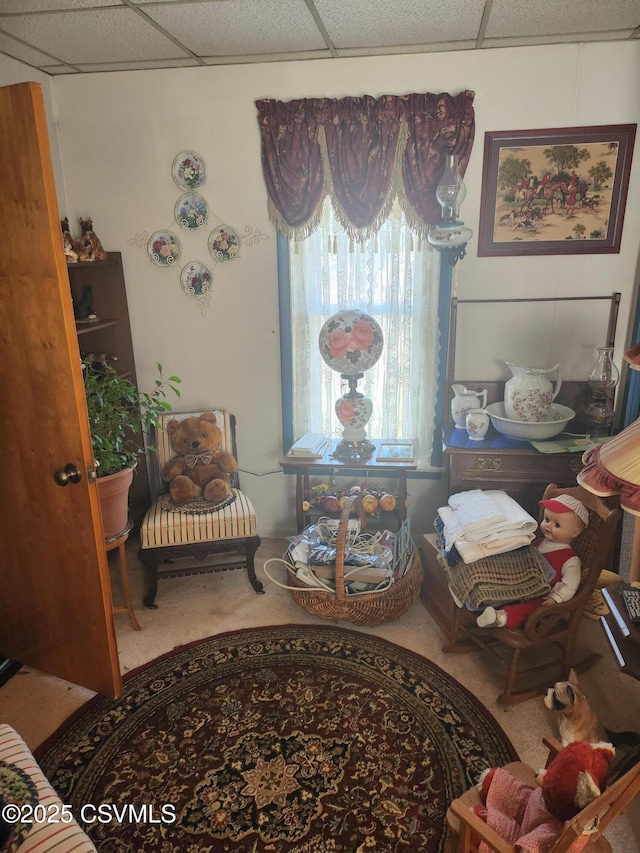 sitting room featuring carpet and a paneled ceiling