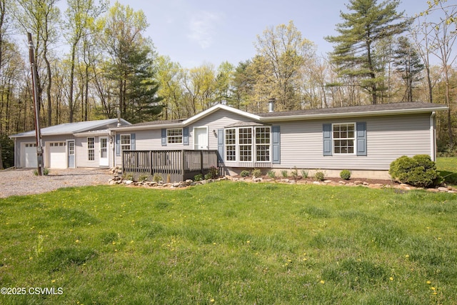 view of front facade featuring a deck, a garage, gravel driveway, and a front lawn
