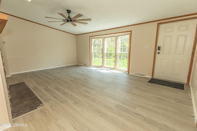 unfurnished living room featuring crown molding, baseboards, ceiling fan, and visible vents