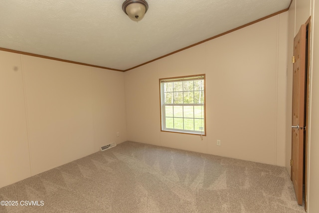 carpeted spare room featuring crown molding, a textured ceiling, visible vents, and lofted ceiling