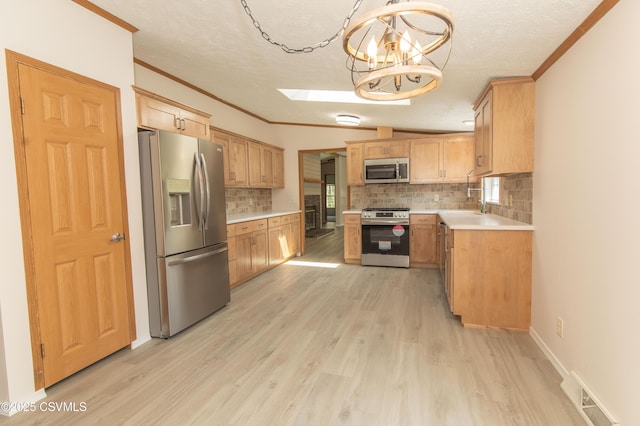 kitchen with stainless steel appliances, visible vents, ornamental molding, and light wood finished floors