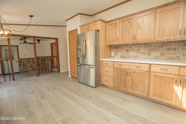 kitchen featuring a ceiling fan, backsplash, stainless steel fridge with ice dispenser, light wood-style floors, and ornamental molding