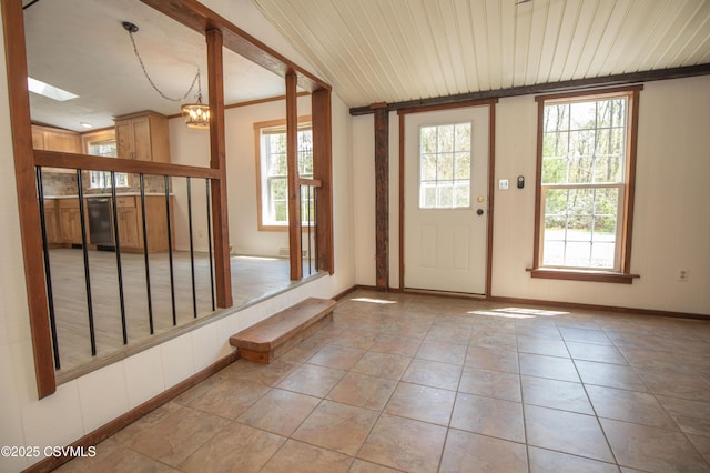 foyer entrance with baseboards, a chandelier, and light tile patterned floors