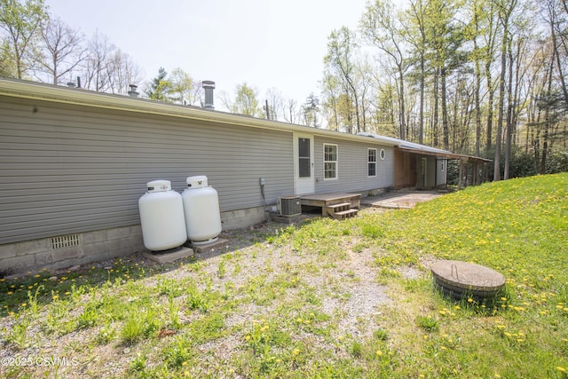 back of property with a lawn, central AC, and crawl space