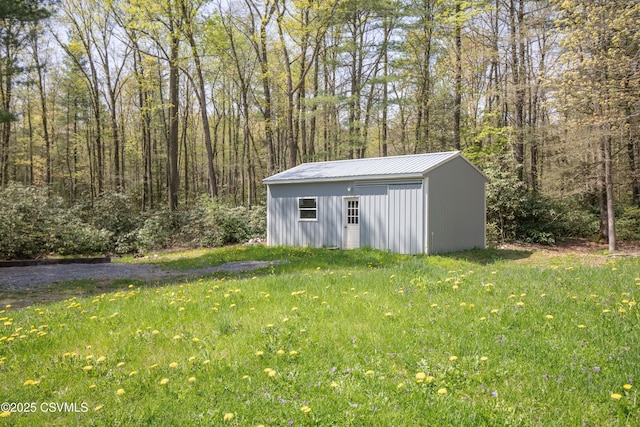 view of outdoor structure featuring an outbuilding and a forest view