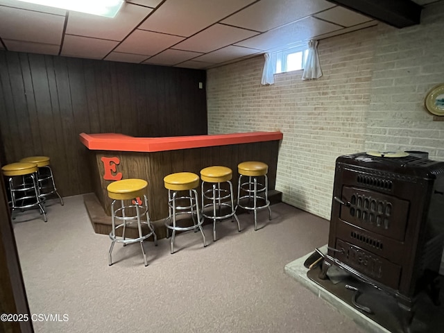 bar featuring carpet flooring, a dry bar, wood walls, and a drop ceiling