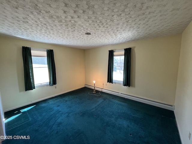 empty room with baseboard heating, baseboards, a healthy amount of sunlight, and visible vents
