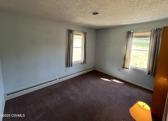 carpeted empty room featuring a baseboard radiator, a wealth of natural light, a textured ceiling, and visible vents