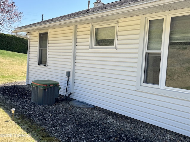 view of side of property featuring a chimney and cooling unit