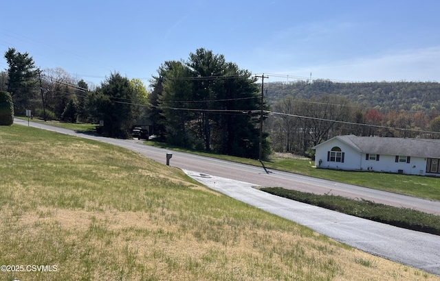 view of road featuring a forest view