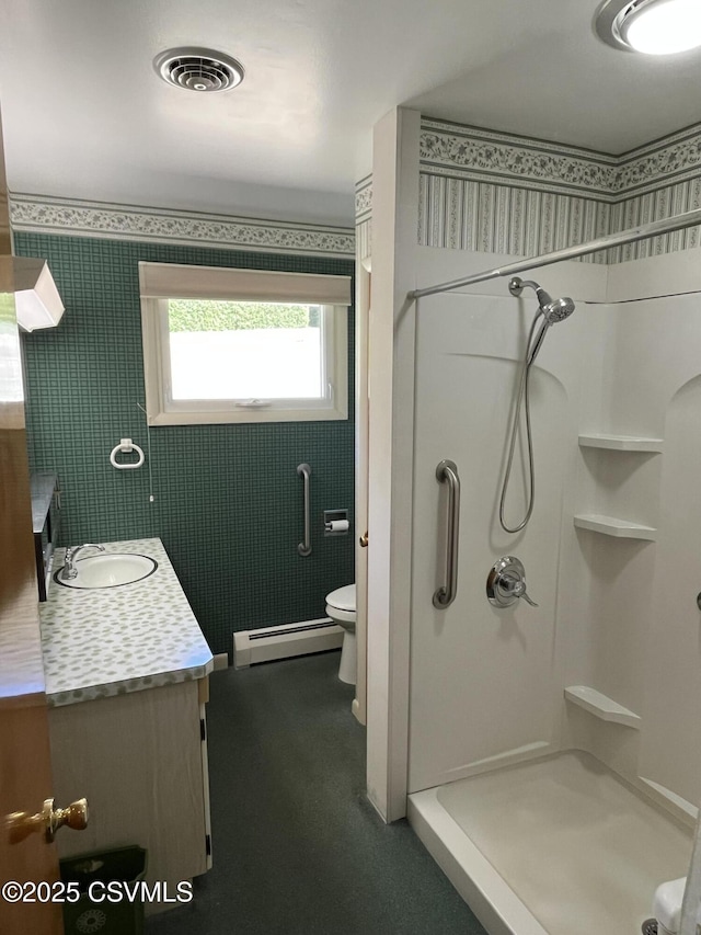 bathroom with visible vents, toilet, vanity, a baseboard radiator, and a stall shower