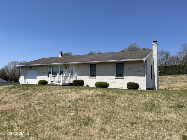 ranch-style home featuring a front lawn, a chimney, brick siding, and a garage