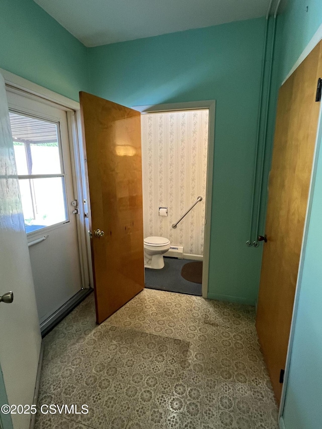 bathroom with a baseboard heating unit and toilet