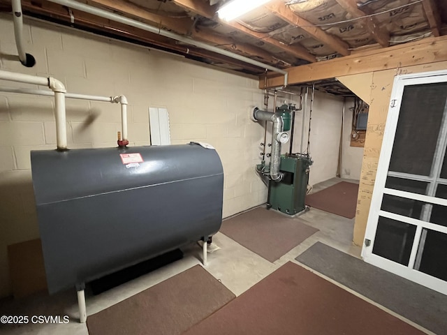 unfinished below grade area with heating fuel, concrete block wall, and a heating unit