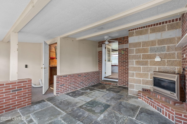 1205 N River Ave, Sunbury, PA 17801 - unfurnished living room with heating unit, stone finish flooring, and a fireplace